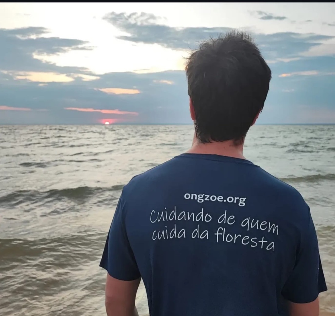 Dr. Pedro Averbach com a camiseta da ONG Zoé diante do pôr do sol, em expedição no Pará